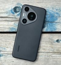 Close-up of a modern smartphone placed on a rustic wooden surface, showcasing its camera design.