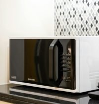 Stylish kitchen setup featuring a black microwave and coffee maker on a counter.